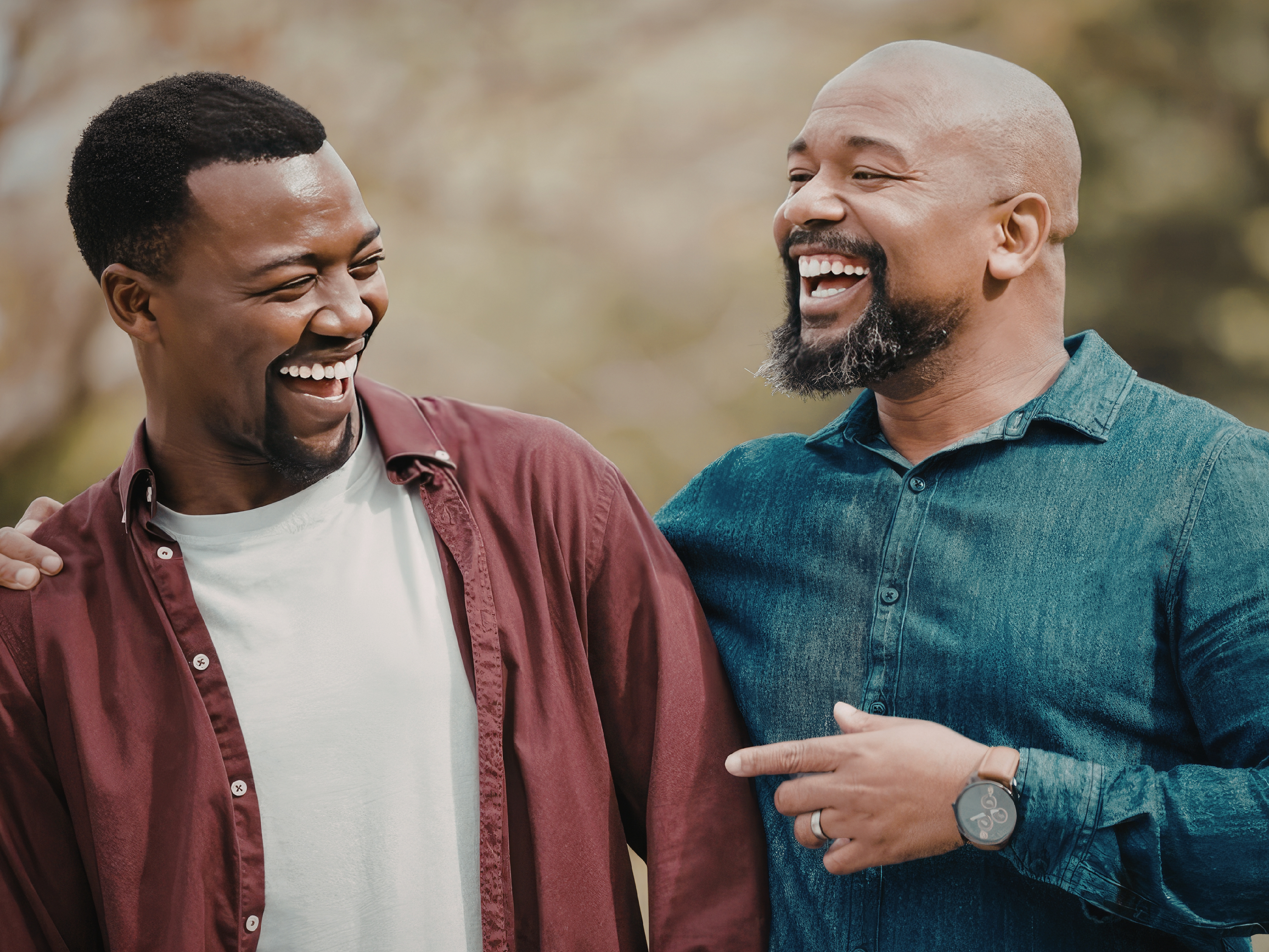 Two Black men laughing together in a candid community moment