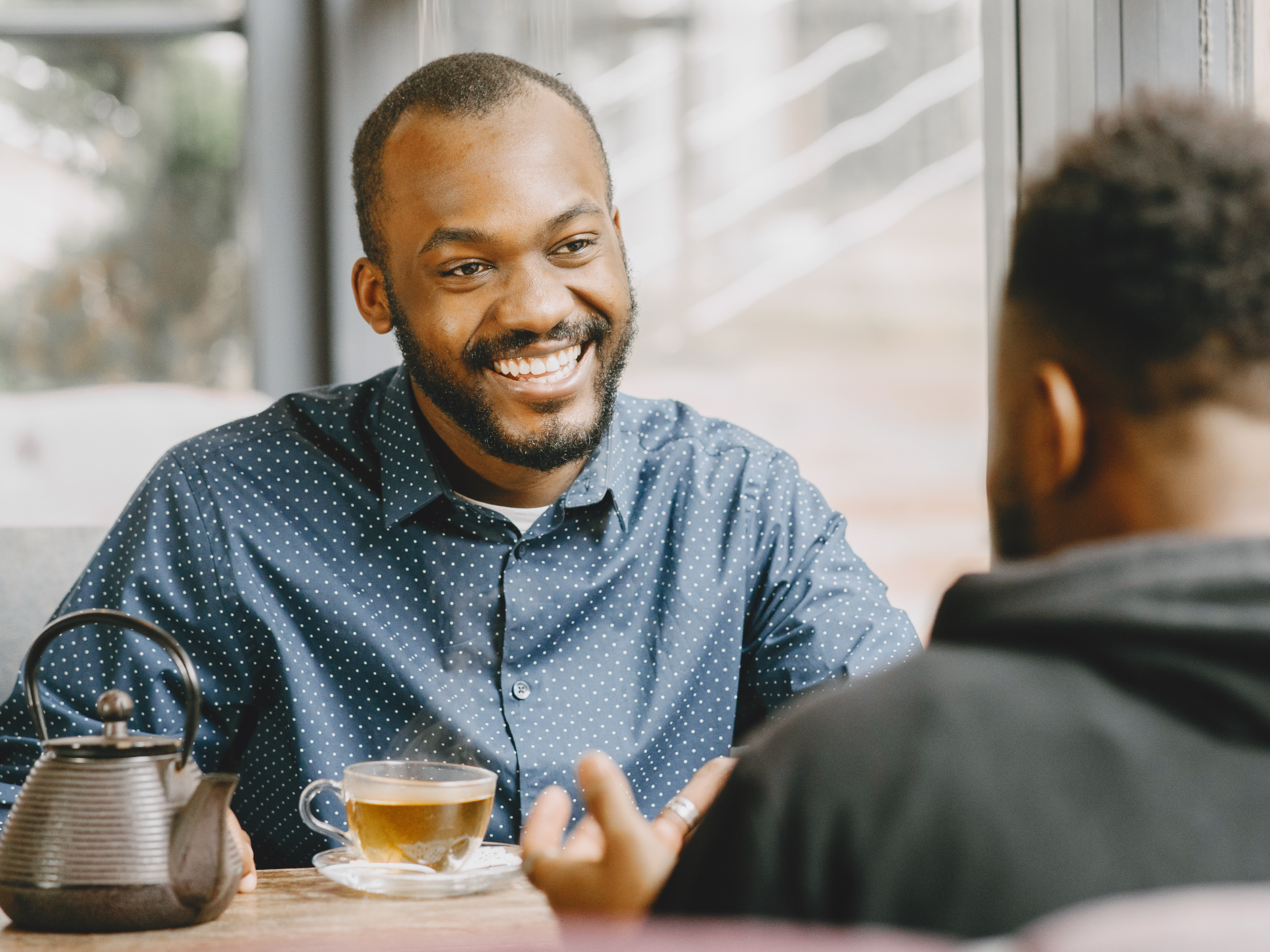 Two professionals sharing a warm conversation over tea