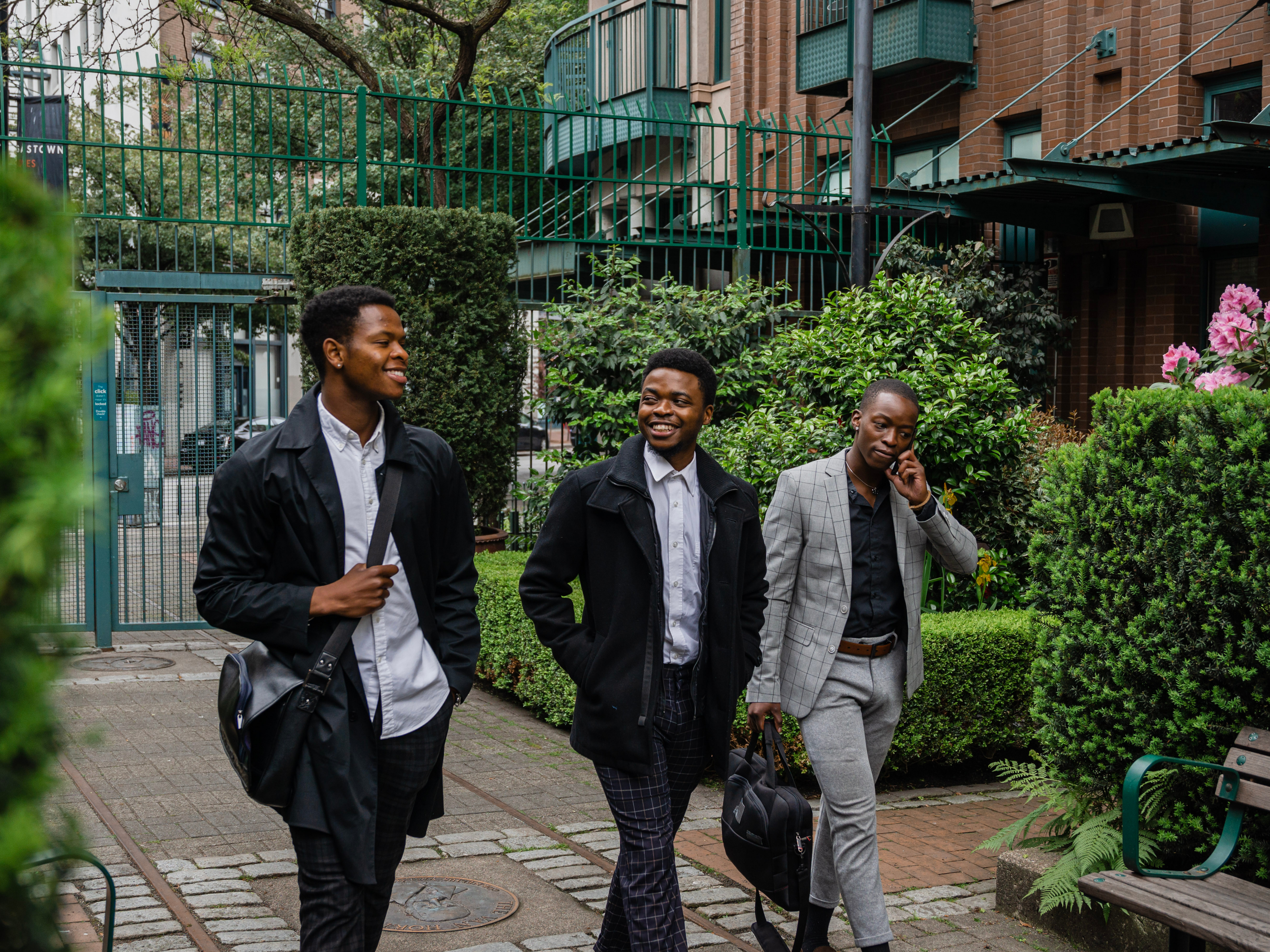 Three young Black professionals walking and talking together