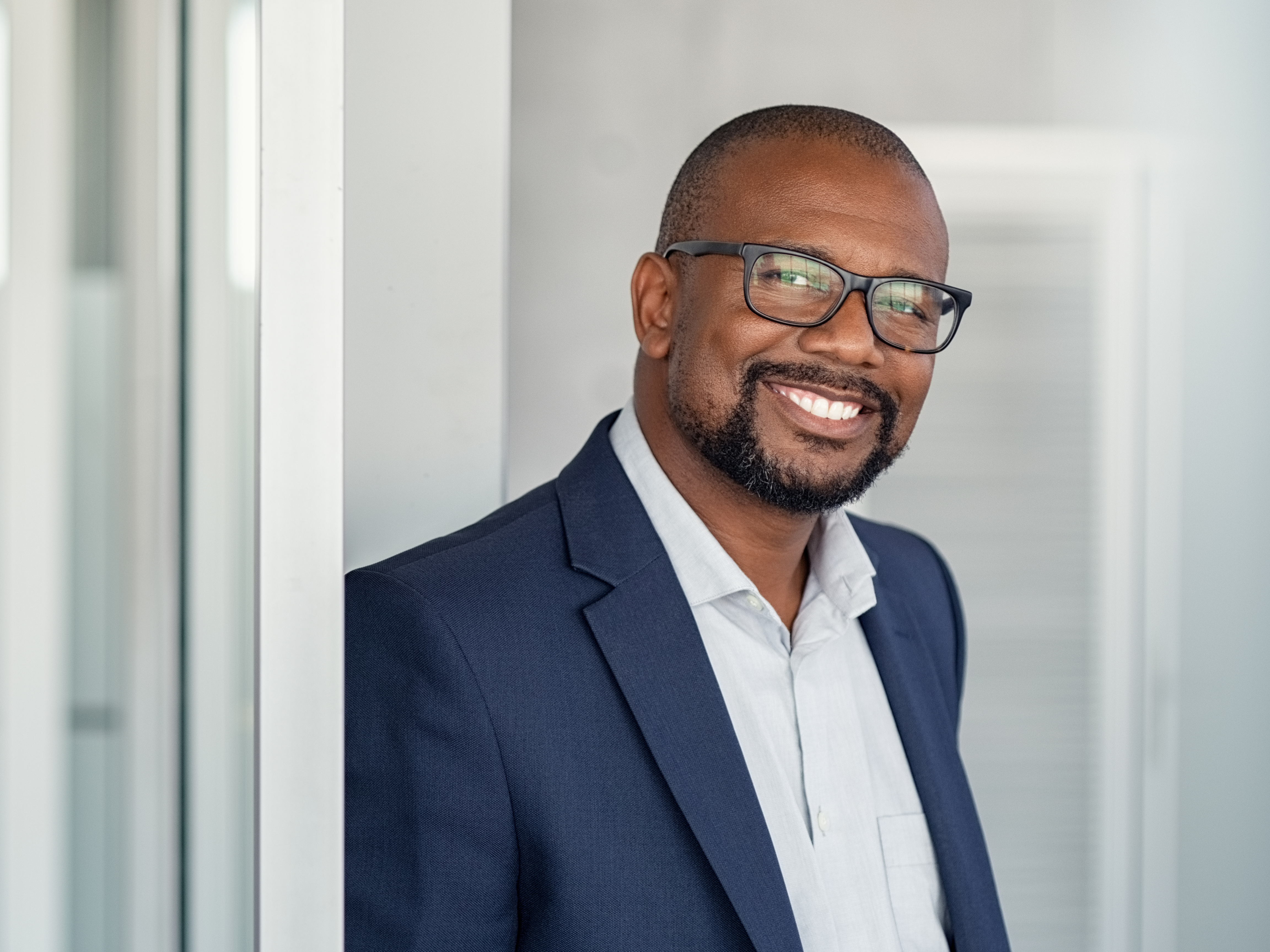 Professional portrait of a Black business leader in a navy blazer